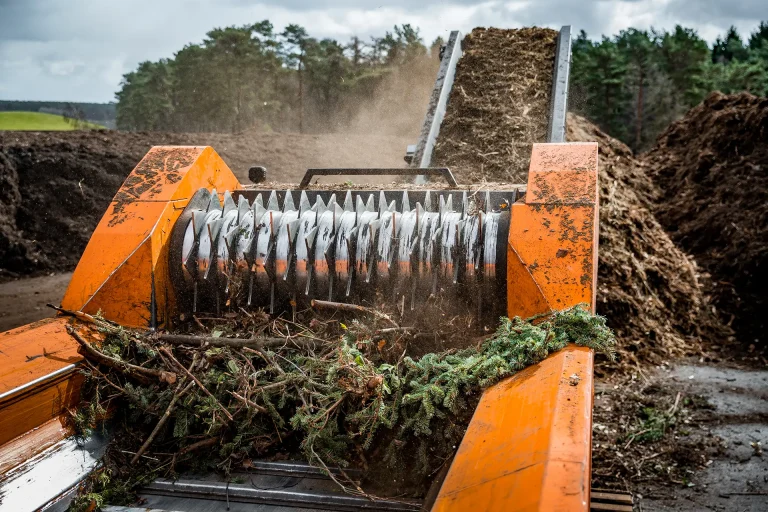 A rotating drum with sharp teeth grinds down green waste to produce mulch.