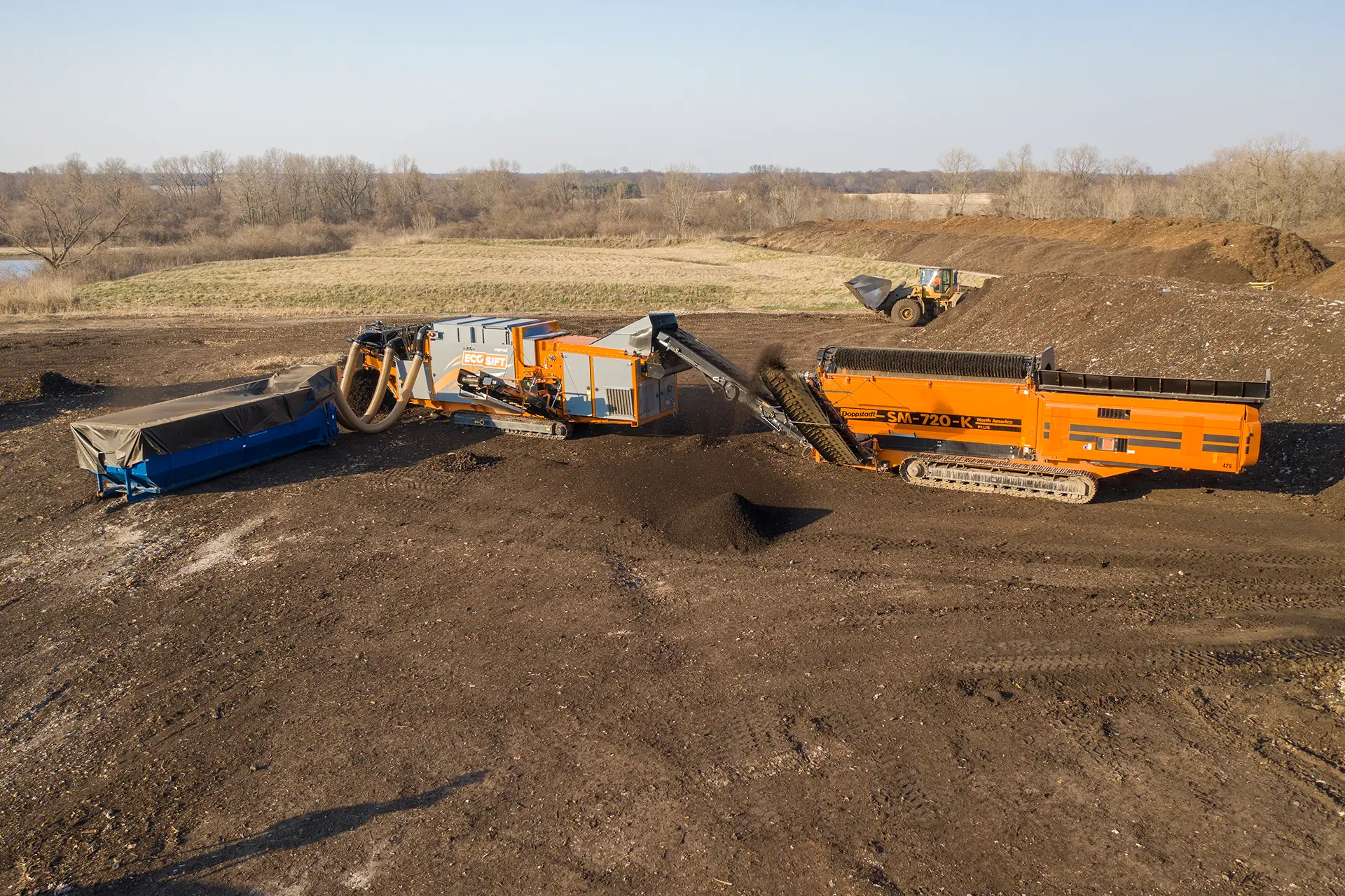 A tracked EcoSift Ventus machine sorts materials fed into it by a Doppstadt trommel screen.
