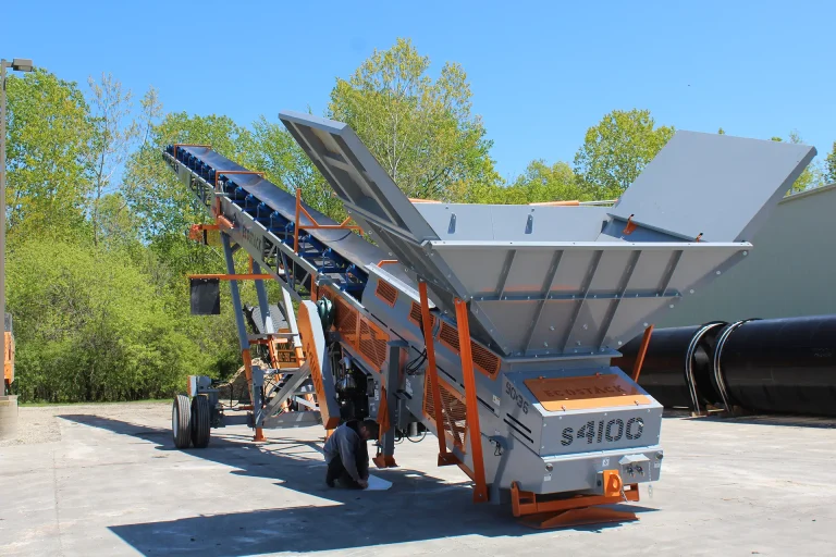 A wheeled EcoStack 9036 stacker / conveyor is shown from the back showing its large hopper.
