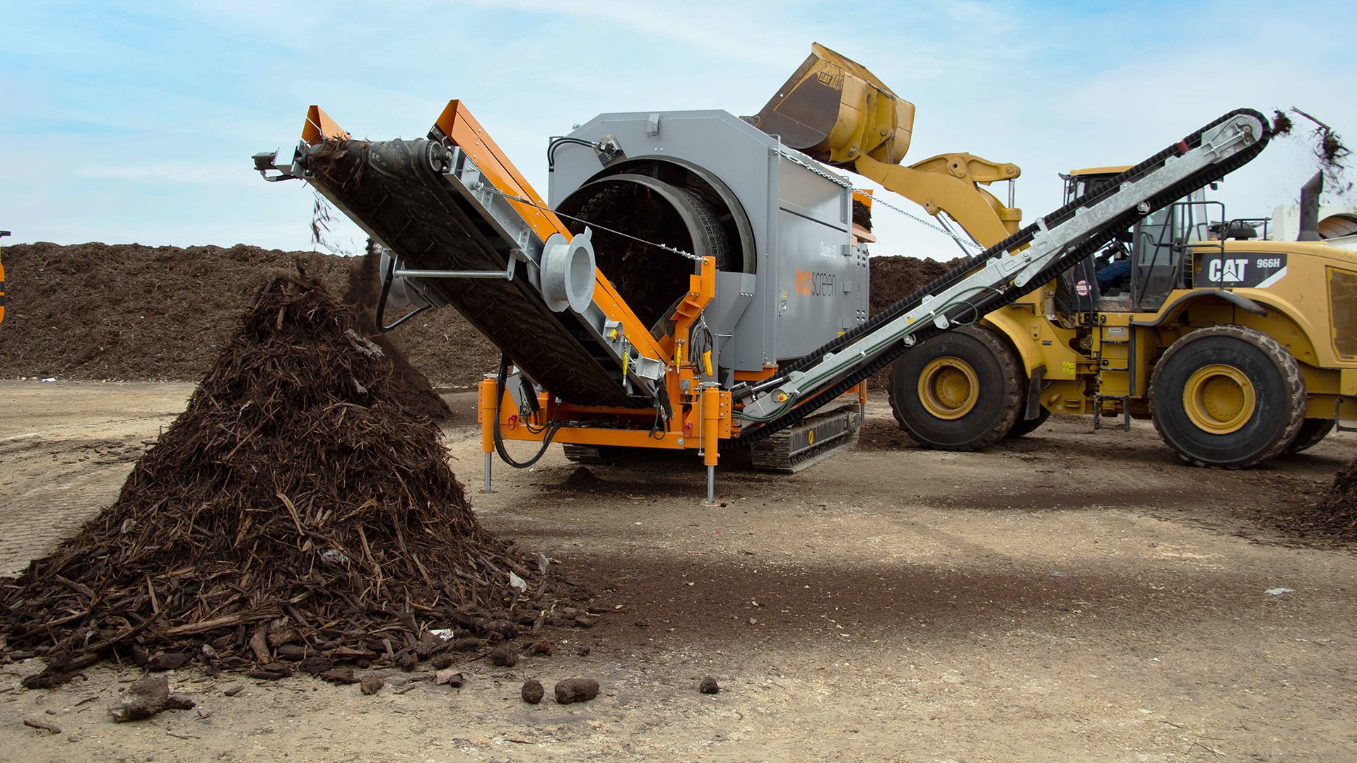 The double drum EcoScreen Duplex 52 trommel screen is separating material into different sized piles.