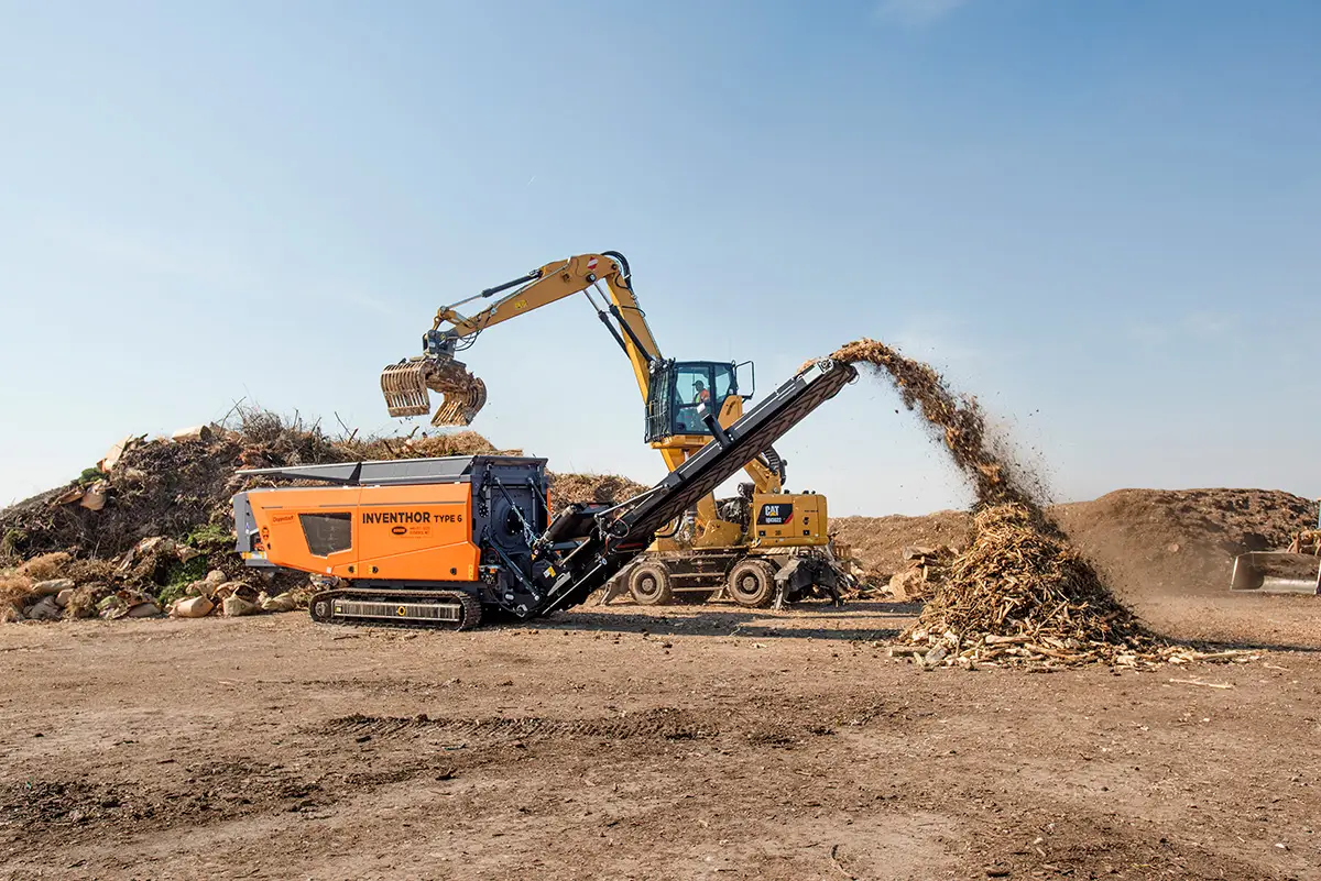 A Doppstadt INVENTHOR shredder is fed green waste to reduce its volume.