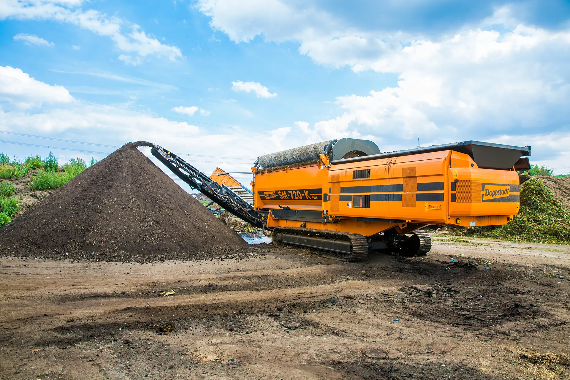 A Doppstadt SM 720 trommel screen piling separated material high.