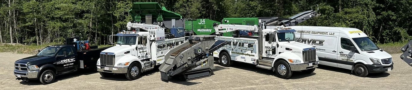 Several trucks from Rock and Recycling are grouped together, side by side.