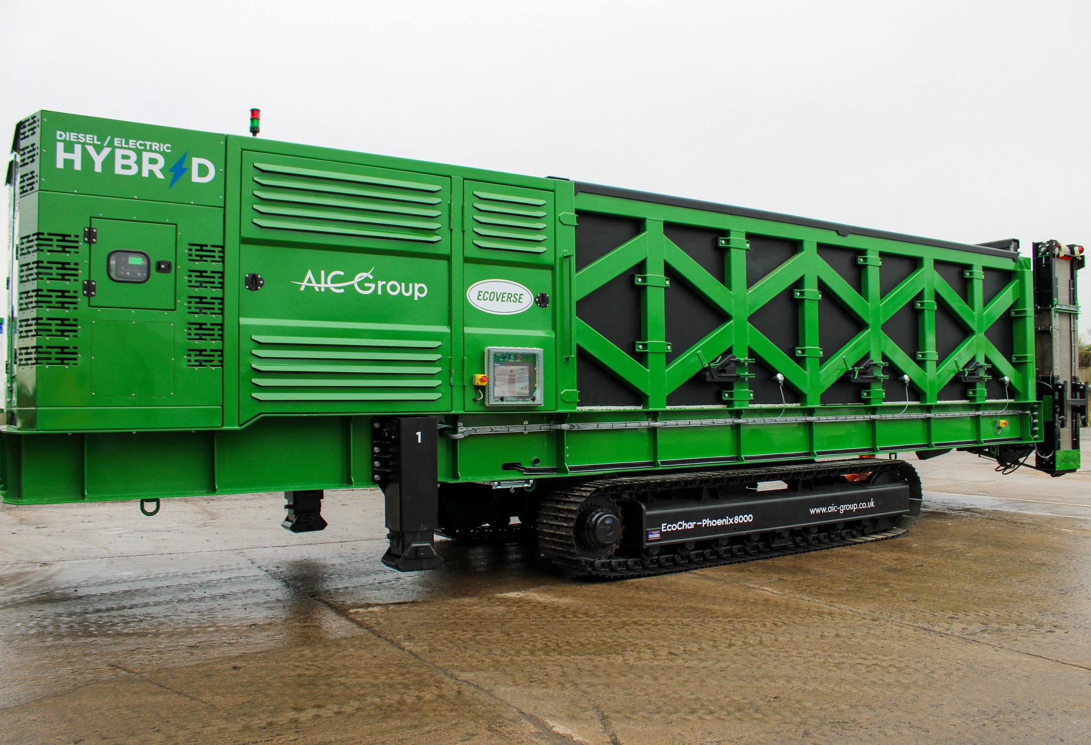 A side view of the green and black EcoChar Phoenix 8000 thermal treatment system machine.