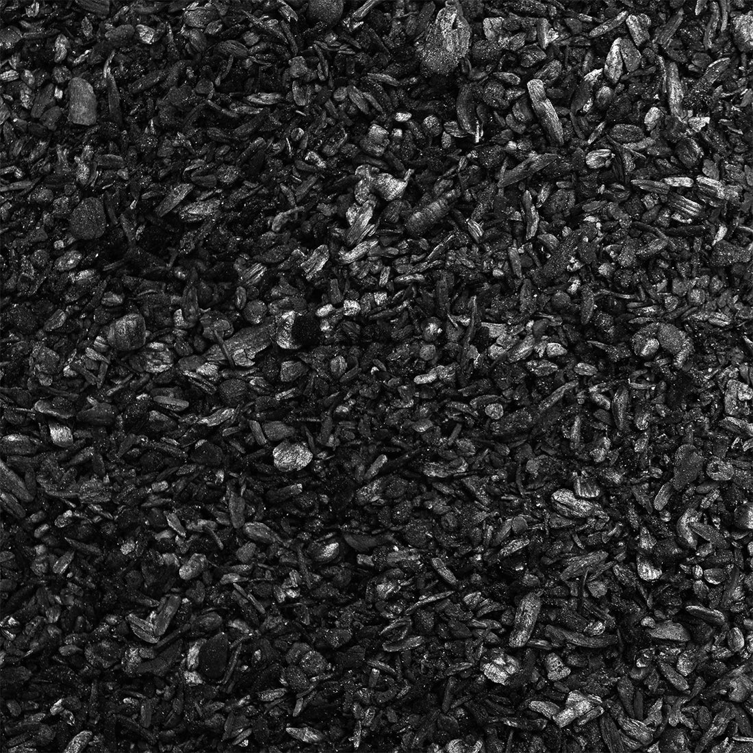 A closeup shot of black biochar, that resembles charcoal but smaller.