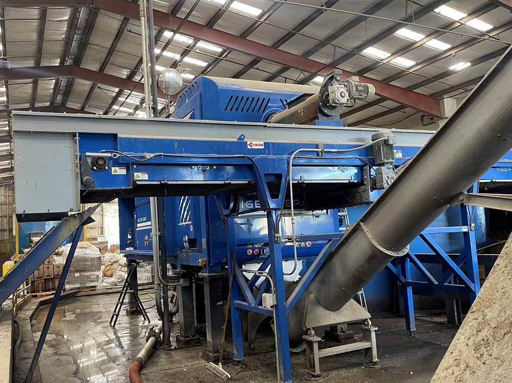 A bright blue Tiger HS-55 depack machine sits in a large steel building.