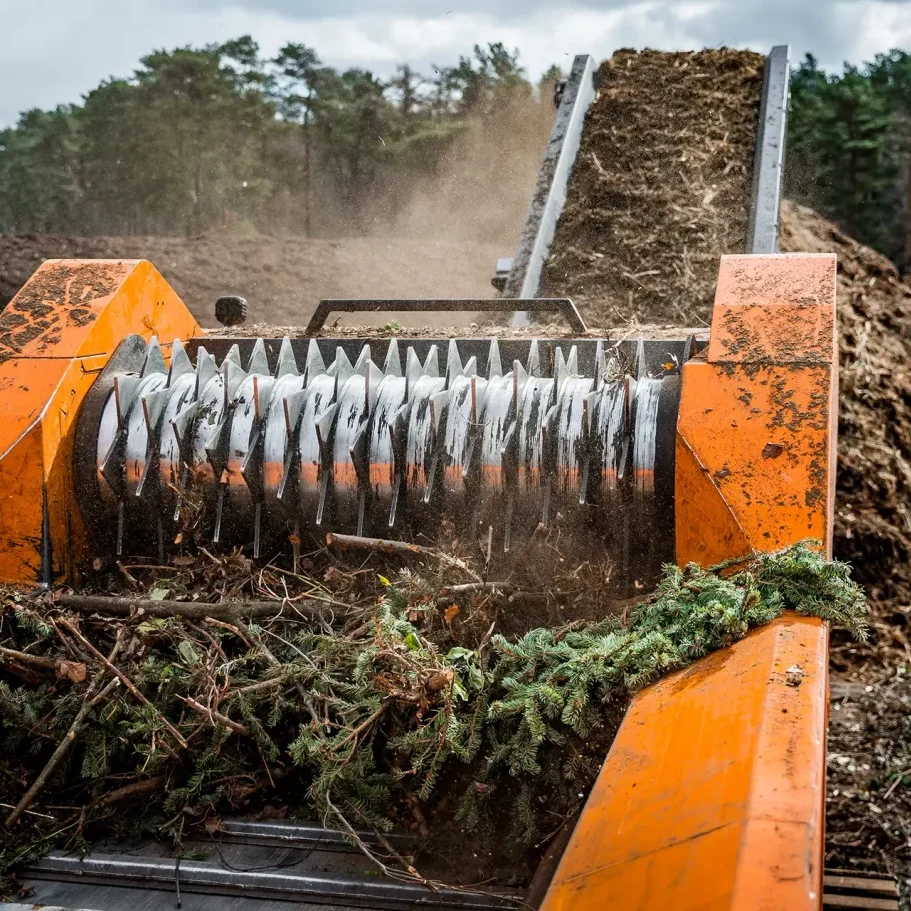 A rotating drum with sharp teeth grinds down green waste to produce mulch.