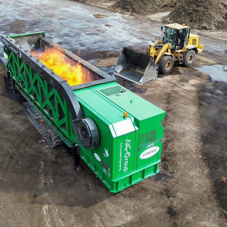 The green and black EcoChar thermal treatment system is seen from overhead, with flames in the combustion chamber.