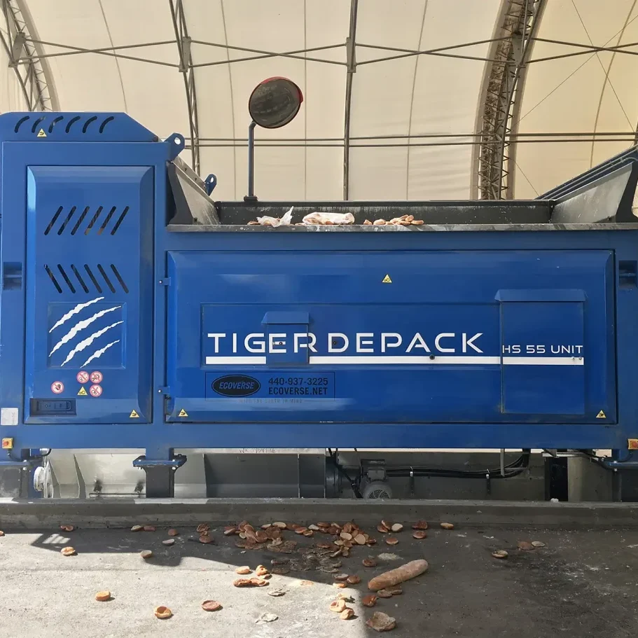 A blue Tiger Depack HS-55 waste food processing machine sits in a covered facility.
