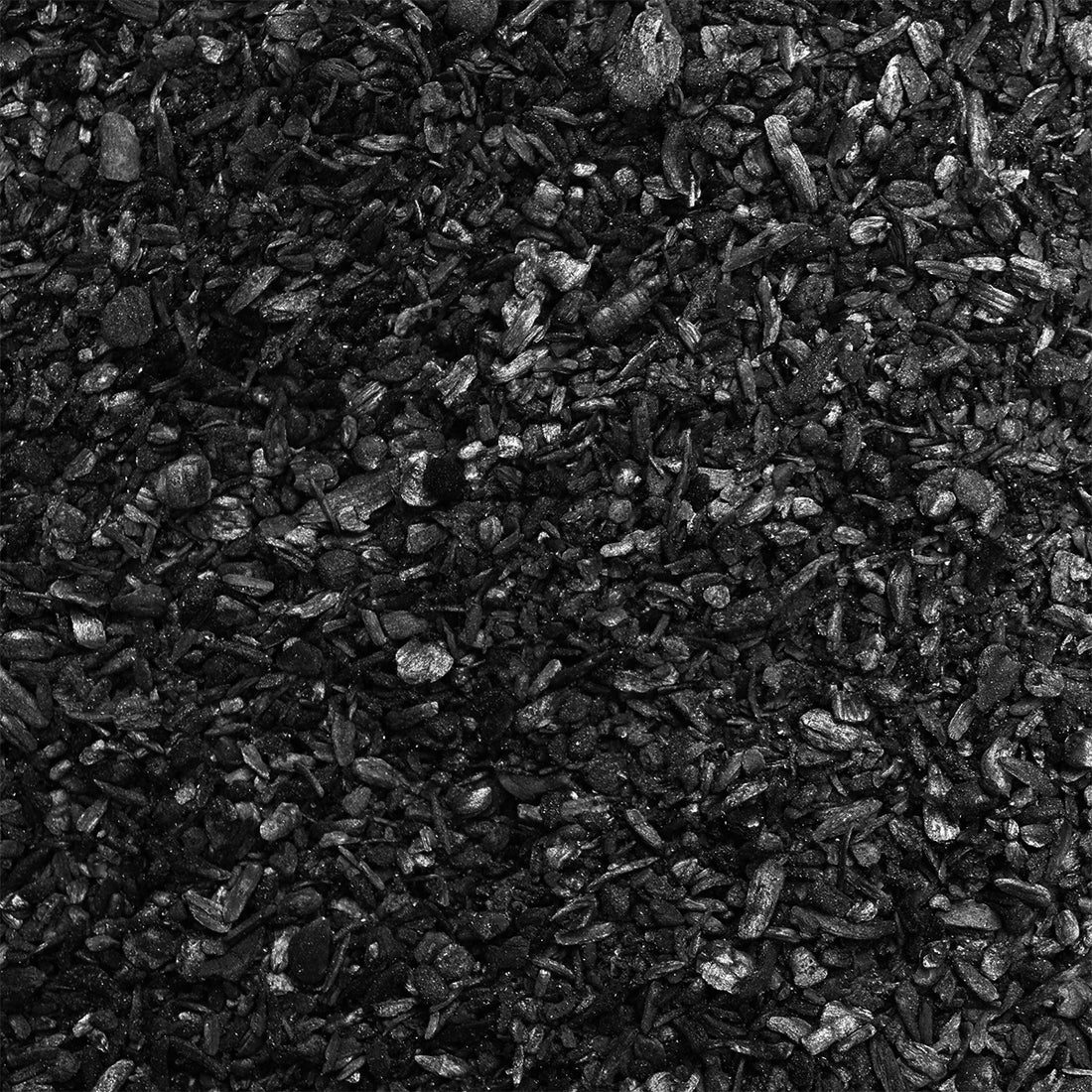 A closeup shot of black biochar, that resembles charcoal but smaller.